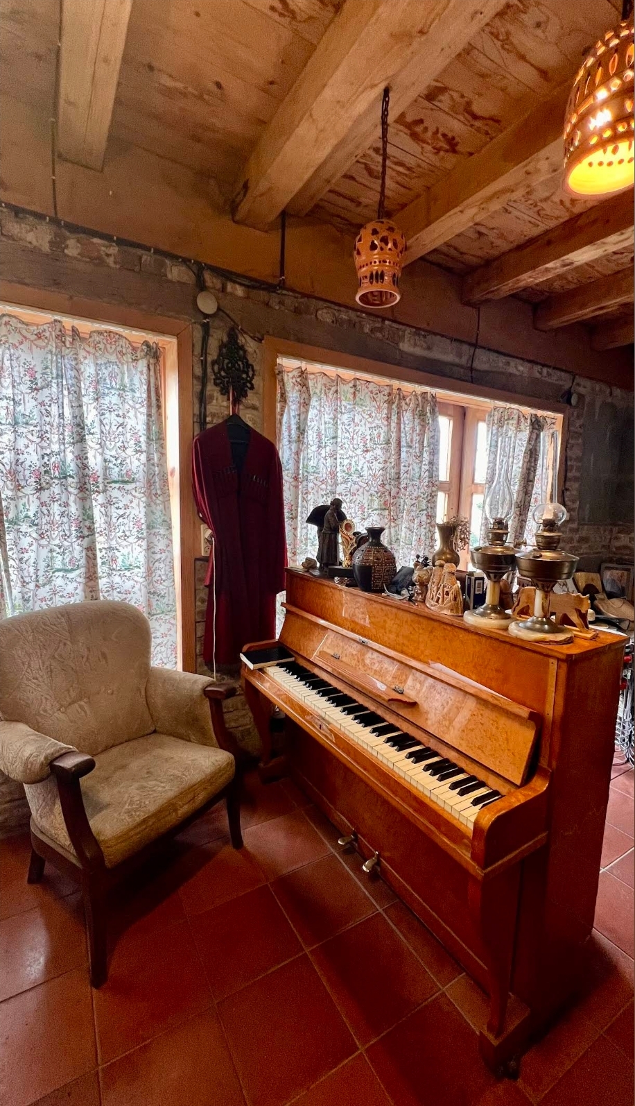 Antique piano in a cozy stone-walled room
